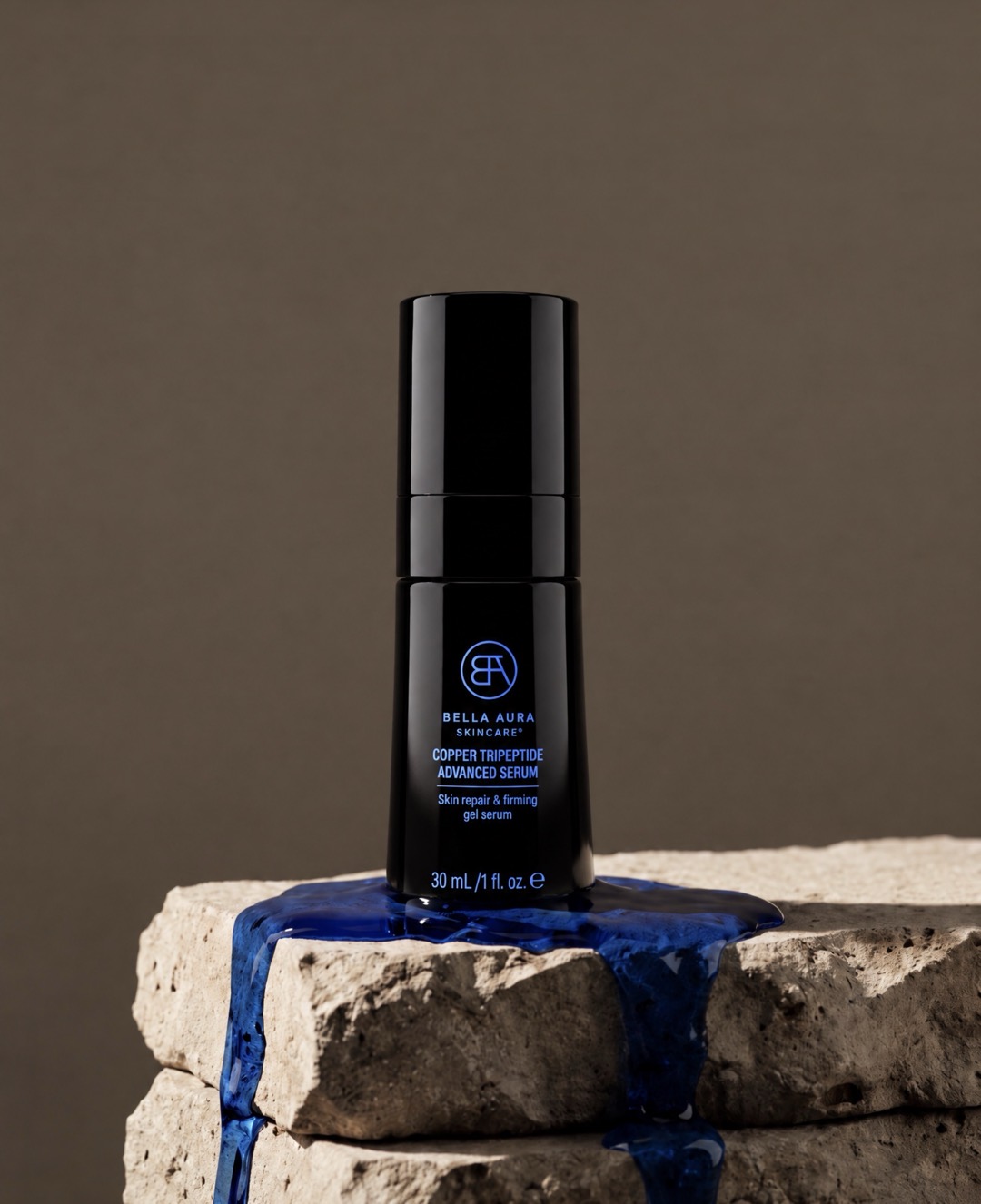 Copper Tripeptide Advanced Serum on stone with deep blue serum flowing around it.