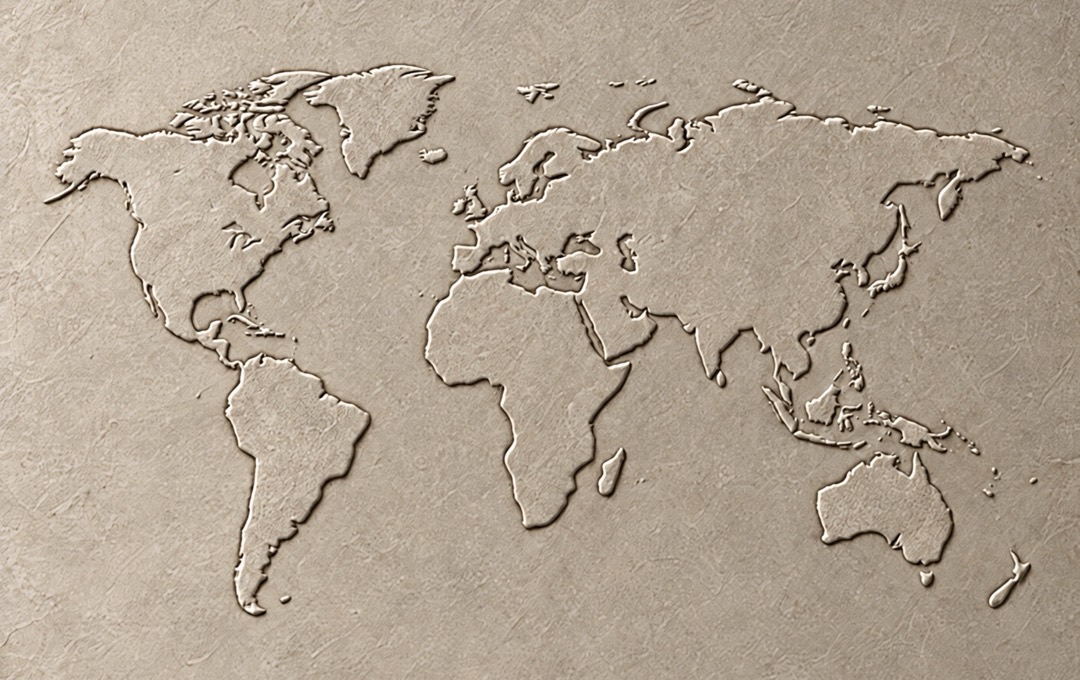 A world map embossed on a textured stone surface.